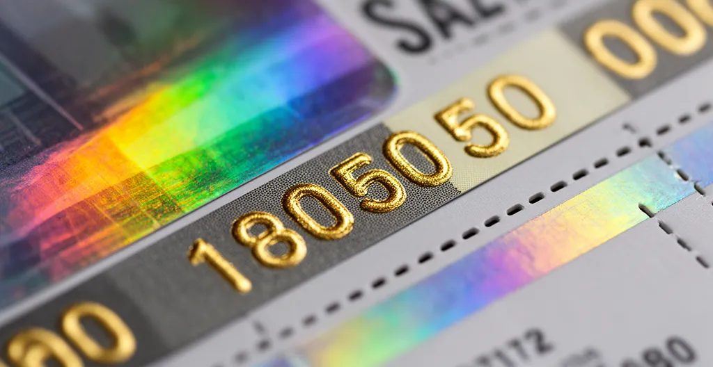 Gros plan sur des billets d'événement sécurisés avec hologrammes iridescents et finitions dorées