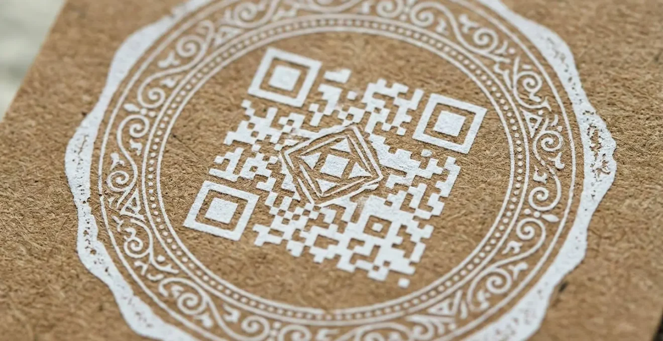QR code artistiquement intégré dans un design vintage sur papier kraft avec encre blanche